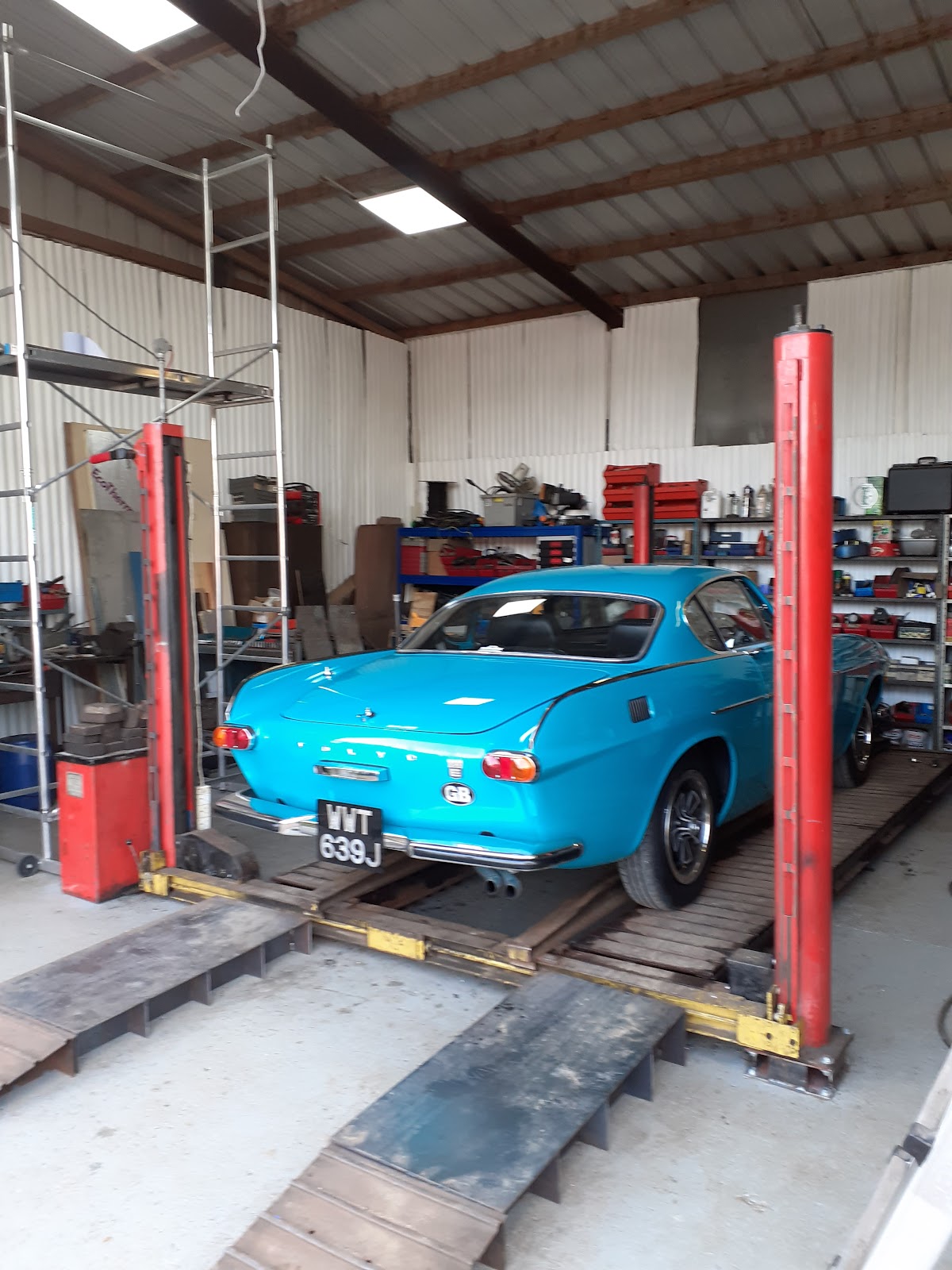 Classic blue Volvo on a lift inside Bradley's Garage